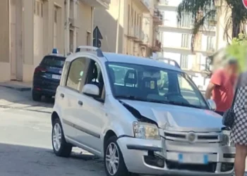 Fiat Panda argento con il muso danneggiato dopo l'incidente a Comiso, auto dei Carabinieri sullo sfondo
