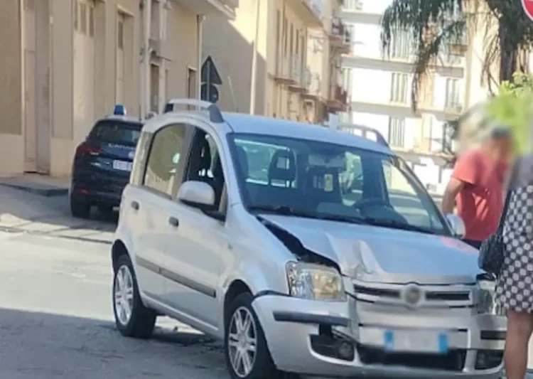 Fiat Panda argento con il muso danneggiato dopo l'incidente a Comiso, auto dei Carabinieri sullo sfondo