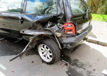 Fiancata posteriore di un'auto danneggiata, con paraurti sfondato e passaruota staccato dopo un incidente