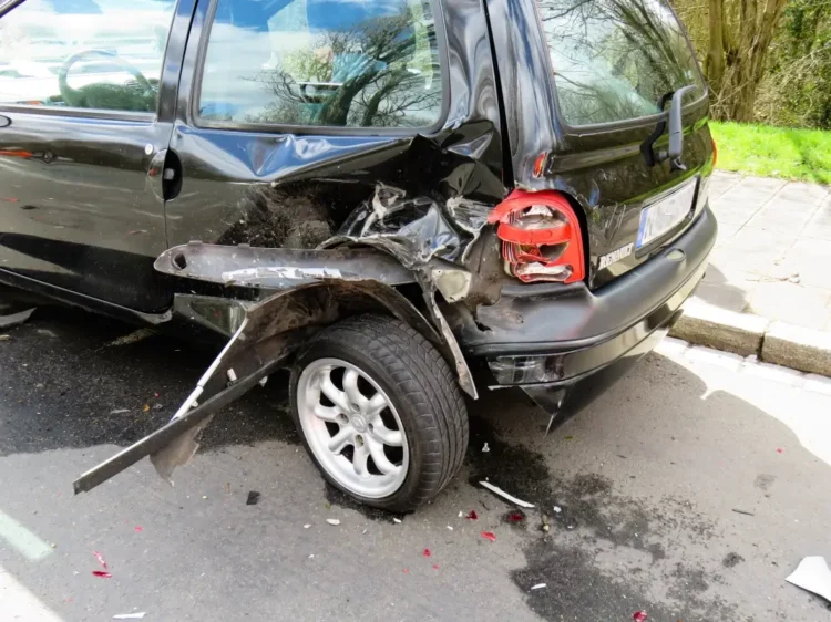 Fiancata posteriore di un'auto danneggiata, con paraurti sfondato e passaruota staccato dopo un incidente
