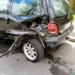 Fiancata posteriore di un'auto danneggiata, con paraurti sfondato e passaruota staccato dopo un incidente