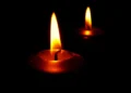 Due candele accese nell'oscurità, simbolo di lutto e cordoglio