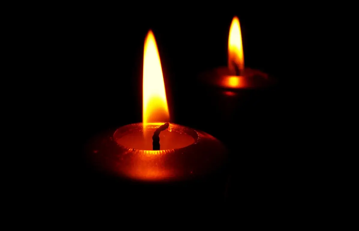 Due candele accese nell'oscurità, simbolo di lutto e cordoglio