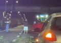Incidente Ragusa, un’auto rossa ribaltata sulla strada durante la notte, con persone e un’auto in primo piano