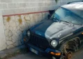 Auto fuoristrada danneggiata con ruota anteriore mancante, ferma vicino a un muro di pietra a Scoglitti