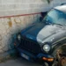 Auto fuoristrada danneggiata con ruota anteriore mancante, ferma vicino a un muro di pietra a Scoglitti