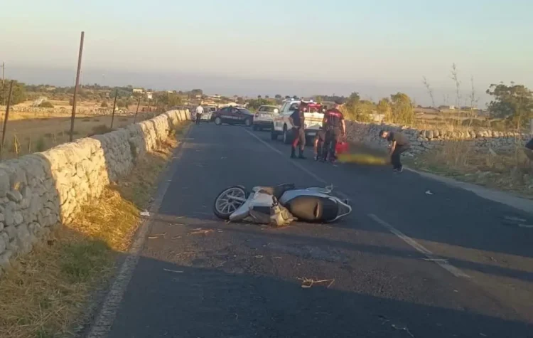 Scooter incidentato sull'asfalto dopo un incidente stradale a Modica, con carabinieri e mezzi di soccorso sul posto