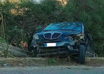 Incidente sulla Sp 85: Lancia scura con il frontale distrutto accanto al guardrail piegato, tra canne e vegetazione