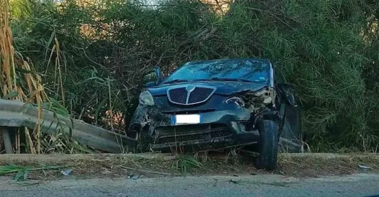 Incidente sulla Sp 85: Lancia scura con il frontale distrutto accanto al guardrail piegato, tra canne e vegetazione