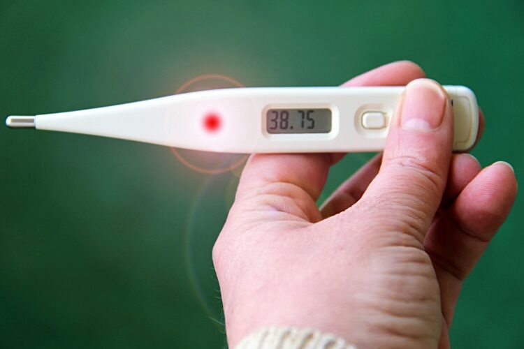 Mano che regge un termometro digitale con 38,75 gradi sul display, febbre alta tipica dei sintomi dell'influenza