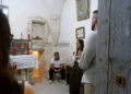 Visita a Scicli in una cappella: quattro persone vicino a un altare con candele rosse e a una targa San Guglielmo