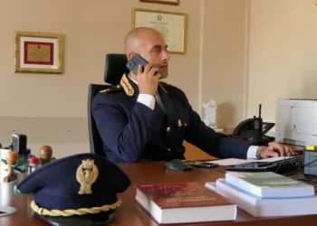 Luca Nania al telefono nel suo ufficio, in uniforme della Polizia di Stato