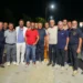 Un gruppo di amministratori posa di sera sulla strada di Sampieri, a Scicli, con i nuovi lampioni accesi sullo sfondo