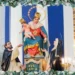 Simulacro della Madonna del Rosario con il Bambino tra due santi domenicani, su un altare ornato di fiori e candele