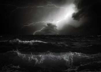 Fulmini attraversano il cielo notturno sopra un mare in tempesta, scena simbolo di un temporale di maltempo