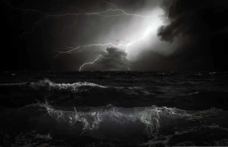Fulmini attraversano il cielo notturno sopra un mare in tempesta, scena simbolo di un temporale di maltempo
