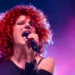 Cantante sul palco mentre canta al microfono durante un concerto