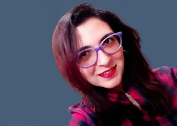 Maria Rita Fazzi sorride con occhiali viola e camicia scozzese rossa