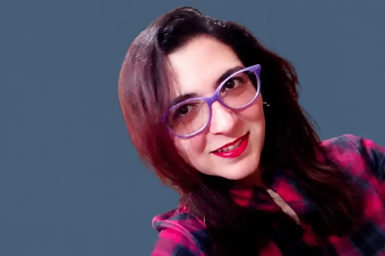 Maria Rita Fazzi sorride con occhiali viola e camicia scozzese rossa