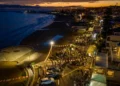 Veduta aerea al tramonto del lungomare di Marina di Ragusa affollato durante Marina Gourmet, tra luci e bancarelle