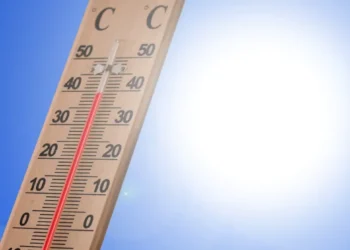 Termometro da esterno con colonnina di mercurio rossa che supera i 40 gradi sotto un cielo azzurro e sole intenso