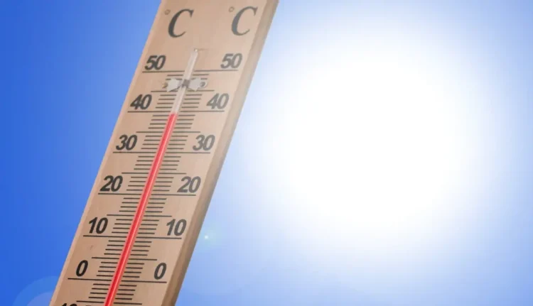 Termometro da esterno con colonnina di mercurio rossa che supera i 40 gradi sotto un cielo azzurro e sole intenso