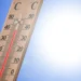 Termometro da esterno con colonnina di mercurio rossa che supera i 40 gradi sotto un cielo azzurro e sole intenso