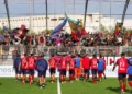 Giocatori del Modica in maglia rossa salutano i tifosi che agitano bandiere in tribuna dopo la gara con il Castrum Favara