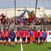 Giocatori del Modica in maglia rossa salutano i tifosi che agitano bandiere in tribuna dopo la gara con il Castrum Favara