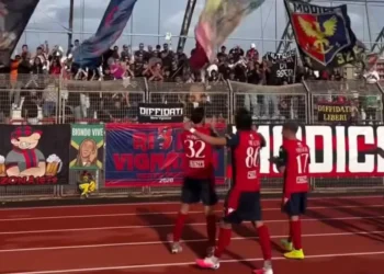 Giocatori del Modica in maglia rossa salutano i tifosi sugli spalti dopo la gara con il Favara Castrum, tra striscioni