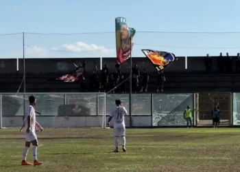 Giocatori del Modica in campo durante la trasferta di Sambiase, tifosi con bandiere sugli spalti