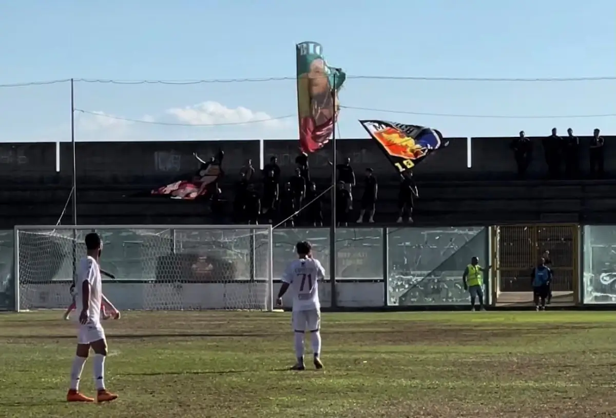 Giocatori del Modica in campo durante la trasferta di Sambiase, tifosi con bandiere sugli spalti