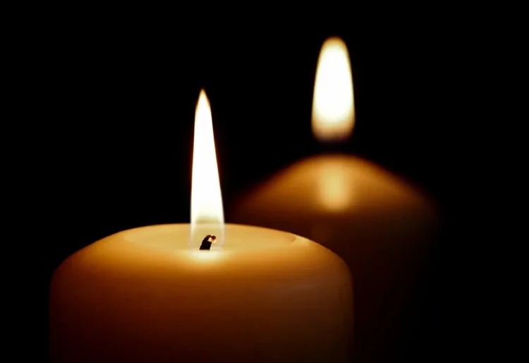 Due candele accese al buio, simbolo di lutto e cordoglio.