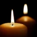Due candele accese al buio, simbolo di lutto e cordoglio.