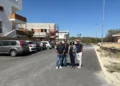 Amministratori comunali su una strada asfaltata di recente a Comiso, con auto parcheggiate sullo sfondo