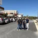 Amministratori comunali su una strada asfaltata di recente a Comiso, con auto parcheggiate sullo sfondo