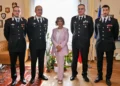 Il Prefetto di Ragusa con quattro ufficiali dei Carabinieri in uniforme, in un ufficio con bandiere e stemmi