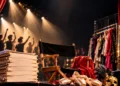 Teatro danza per INSCENA di Olimpo Company: sedia da regista, scarpette da punta, ballerini sotto i riflettori. Immagine da locandina