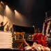 Teatro danza per INSCENA di Olimpo Company: sedia da regista, scarpette da punta, ballerini sotto i riflettori. Immagine da locandina