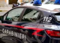 Auto dei Carabinieri con lampeggianti blu e scritta 112, ripresa di lato mentre è parcheggiata in una via cittadina