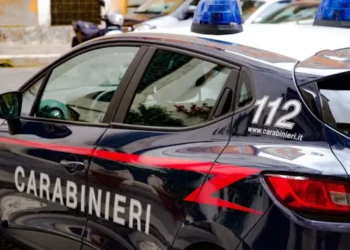 Auto dei Carabinieri con lampeggianti blu e scritta 112, ripresa di lato mentre è parcheggiata in una via cittadina