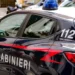 Auto dei Carabinieri con lampeggianti blu e scritta 112, ripresa di lato mentre è parcheggiata in una via cittadina
