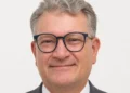 Ritratto di Paolo Ferrara, vicecommissario provinciale del Movimento per l'Autonomia, con occhiali e giacca grigia