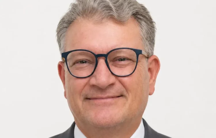Ritratto di Paolo Ferrara, vicecommissario provinciale del Movimento per l'Autonomia, con occhiali e giacca grigia