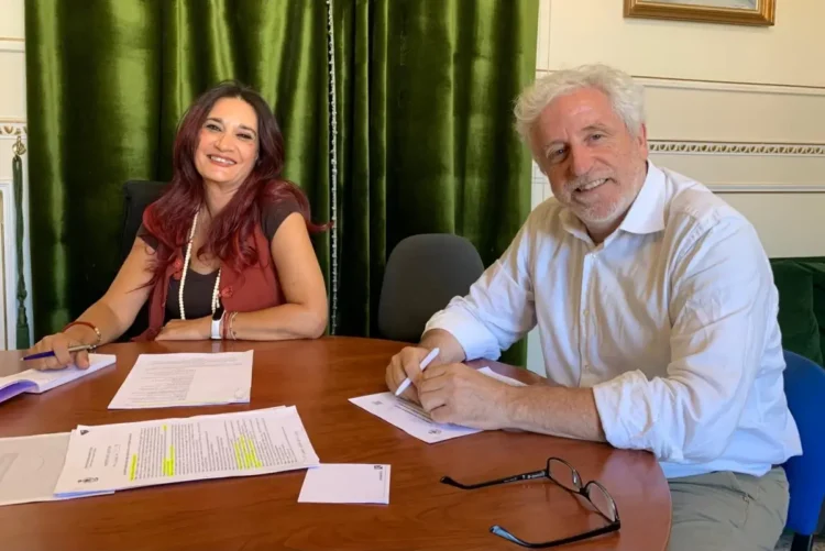 Loredana Papotto e il sindaco Mario Cutello firmano documenti seduti a un tavolo in un ufficio comunale