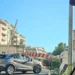 Sbarra del passaggio a livello di via Paestum a Ragusa appoggiata su un'auto grigia, con il semaforo rosso acceso
