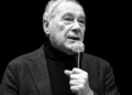 Pietro Grasso al microfono durante un intervento pubblico, foto in bianco e nero con grafica promozionale