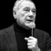 Pietro Grasso al microfono durante un intervento pubblico, foto in bianco e nero con grafica promozionale