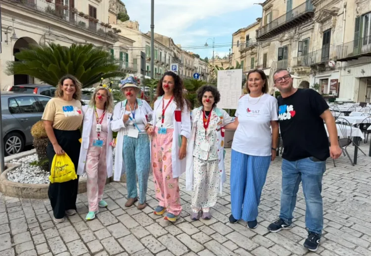 Pigiama Run Modica: sette persone in posa in piazza, quattro con camice e naso rosso da clown, una con maglietta LILT