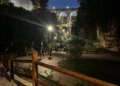 Vialetti illuminati del Parco degli Iblei a Ragusa, nella vallata Santa Domenica, con persone a passeggio e il ponte ad arcate